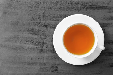 Cup of tea on grey background, top view