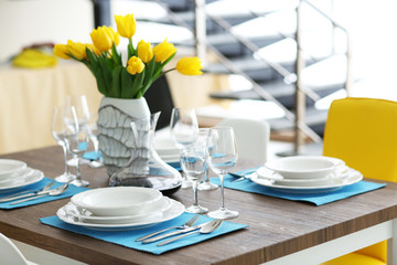 Table served with dishes and a bouquet of tulips