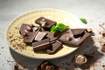 Broken black chocolate with hazelnuts and fresh mint on a plate
