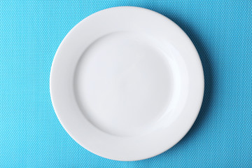Empty plate on blue textured mat background