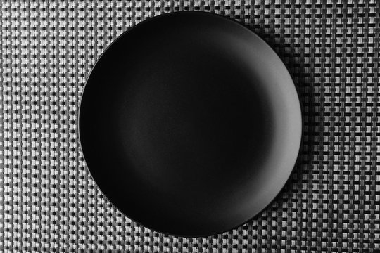 Empty plate on wicker mat background