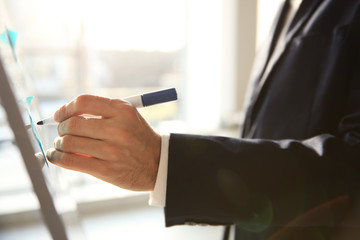 Businessman drawing schedule on whiteboard