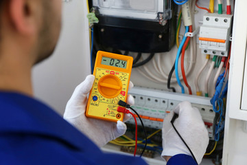 Male hands checking work of switch box closeup