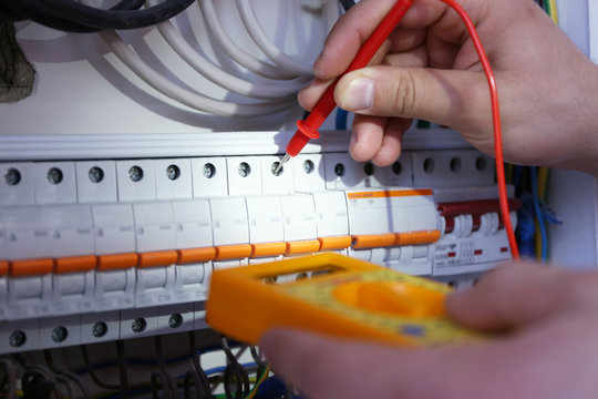 Male hands checking work of switch box closeup