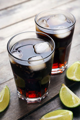 Glasses of soda water and sliced lime on wooden table