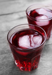 Glasses of red soda water on wooden table