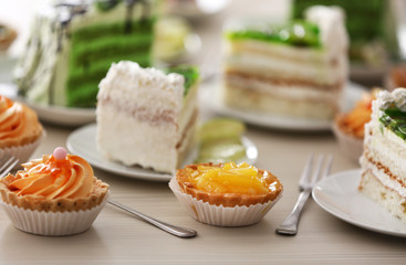 Pieces of lime cake and fruit tarts on table