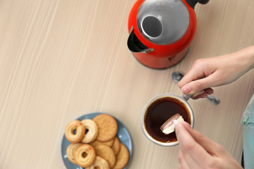 Woman with a cup of tea at the table, top view