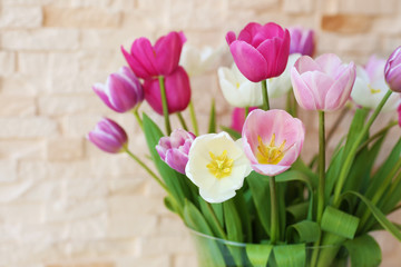 Bouquet of beautiful tulips on brick wall background