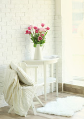Beautiful tulips on white wooden table