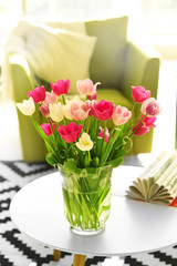 Beautiful fresh tulips on round table