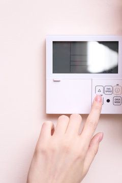 Woman switching a digital thermostat