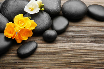 Fototapeta na wymiar Beautiful spa composition with stones and freesia on wooden background