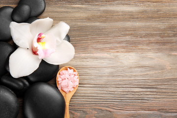 Beautiful spa composition with stones and orchid on wooden background