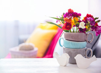 Beautiful freesia flowers on table in room