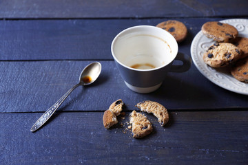 Empty coffee cup with cookies on wooden table