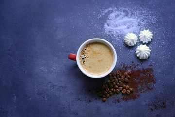 Obraz na płótnie Canvas Cup of coffee with zephyr on dark blue table
