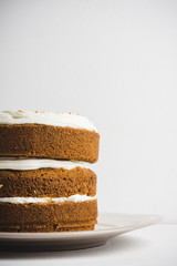 Cake with cream on the white wooden background