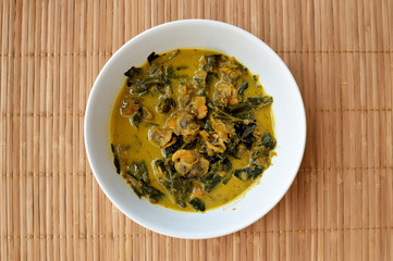 Thailand spicy cockle curry with wood background