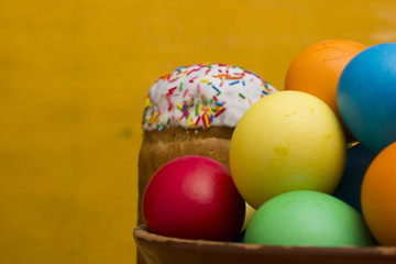 Fototapeta na wymiar Easter eggs of different colors and cake