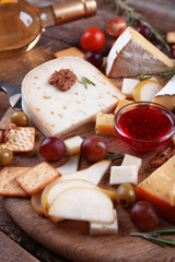 Different kinds of cheese on wooden background