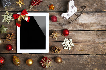 Tablet and Christmas decor on wooden background