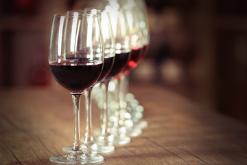 Many glasses of different wine in a row on bar counter