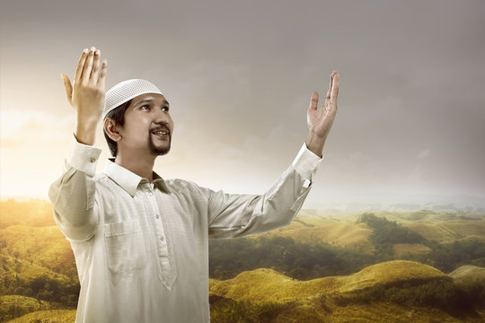 Young muslim man praying on the mountain