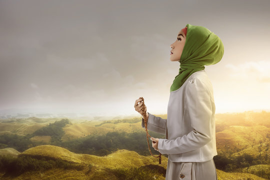 Young muslim woman holding prayer beads