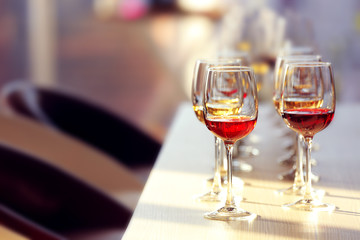 Many glasses of different wine in a row on a table