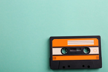 Old audio cassette on turquoise background