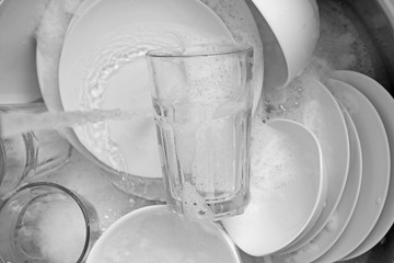 Pile of dishes in sink closeup