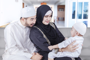 Two Arabic parents playing with their son
