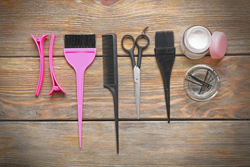 Hairdresser set with various accessories on wooden background