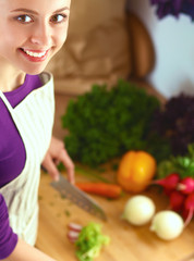 Young woman cutting vegetables in the kitchen