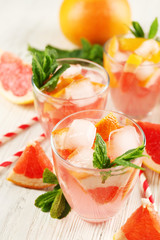 Ripe grapefruits and fresh juice with mint, close up