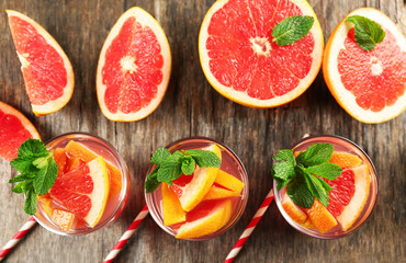 Fototapeta na wymiar Ripe grapefruits and fresh juice with mint, close up