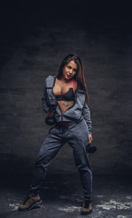 Sexy female undressing in studio over grey background.