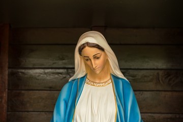 Virgin mary statue on wooden background