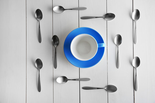 Ceramic cup and silver spoons, top view