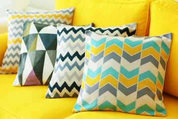 Stylish pillows on yellow couch