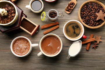 Assorted fresh coffee with spices on wooden table, top view