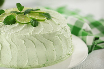 Delicious creamy lime cake on wooden table closeup