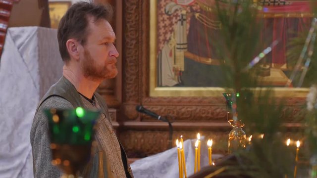 Man is Crossing Himself Christmas at the Holy Mountain Lavra Dormition Cathedral Ukraine Candles Burning Worshiper is Looking Concentratedly Praying