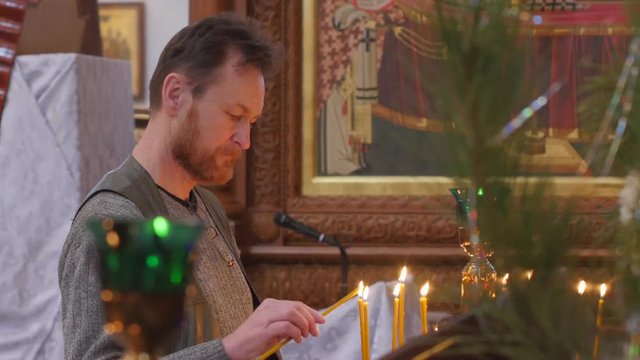 Man Lights a Candle Christmas at Holy Mountain Lavra Dormition Cathedral Ukraine Candles Burning Worshipers Are Standing at Church Looking Praying