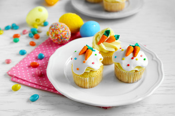 Plate with Easter cupcakes and eggs on napkin
