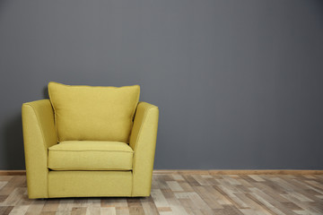 Green armchair on dark grey wall background