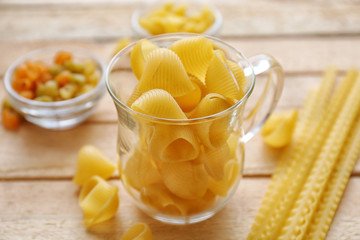 Pipe rigate pasta in cup on wooden table background