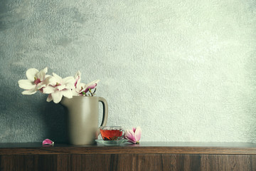 Cup of tea and magnolia on table