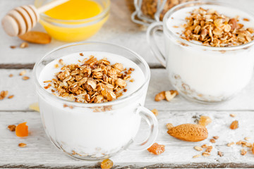 yogurt with homemade granola, nuts and dried fruits in a glass cup